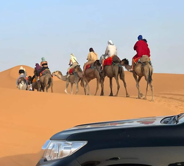 4x4 vehicle driving over Sahara dunes during a Morocco desert tour